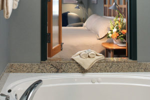 guest room with one king bed and jetted tub